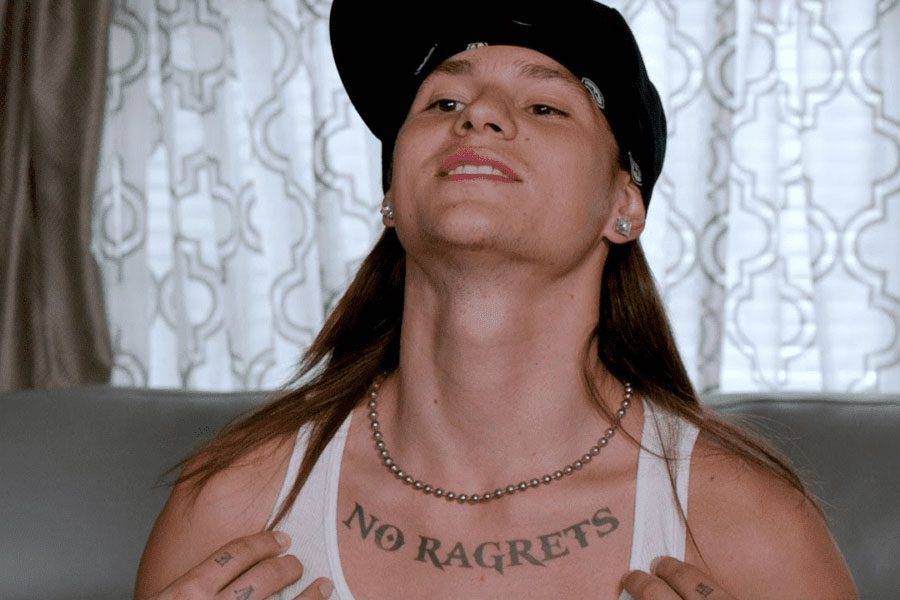 Scotty P. from We're The Millers,
showing a tattoo that reads 'NO RAGRETS'
